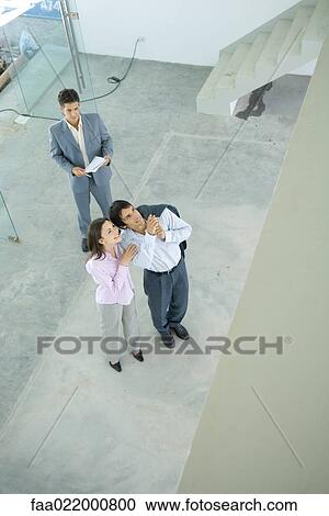 Real estate agent showing unfinished house to enthusiastic young couple, high angle view View Large Photo Image Stock Image - Real estate agent showing unfinished house to enthusiastic young couple, high angle view. Fotosearch