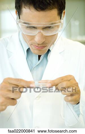 Researcher wearing protective goggles picking up Petri dish View Large Photo Image Stock Image - Researcher wearing protective goggles picking up Petri dish. Fotosearch