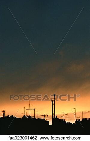 Stock Image - Roofline silhouetted against sky at twilight. Fotosearch