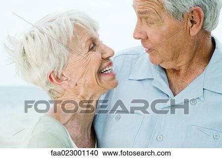 Senior couple looking at each other, woman smiling, man raising eyebrows View Large Photo Image Stock Image - Senior couple looking at each other, woman smiling, man raising eyebrows. Fotosearch
