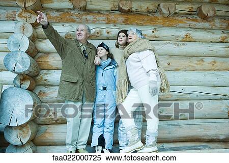 Senior couple standing with teen and preteen granddaughters in front of log cabin, man pointing to the distance View Large Photo Image Stock Photography - Senior couple standing with teen and preteen granddaughters in front of log cabin, man pointing to the distance. Fotosearch