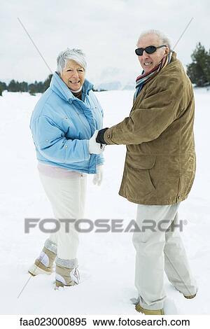 Senior couple walking together, holding hands, smiling over shoulders at camera View Large Photo Image Stock Photography - Senior couple walking together, holding hands, smiling over shoulders at camera. Fotosearch