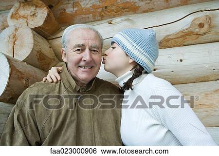 Senior man smiling at camera, granddaughter kissing his cheek, portrait View Large Photo Image Stock Photograph - Senior man smiling at camera, granddaughter kissing his cheek, portrait. Fotosearch