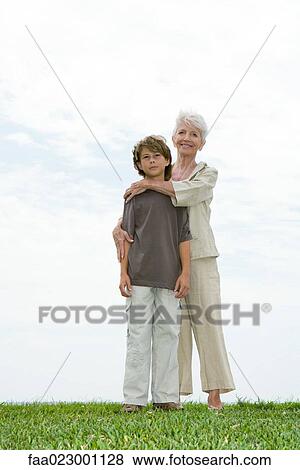 Senior woman and grandson, standing on grass, full length View Large Photo Image Stock Photo - Senior woman and grandson, standing on grass, full length. Fotosearch