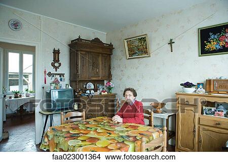Senior woman sitting in home interior View Large Photo Image Picture - Senior woman sitting in home interior. Fotosearch