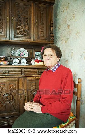 Senior woman sitting in home interior View Large Photo Image Stock Photo - Senior woman sitting in home interior. Fotosearch