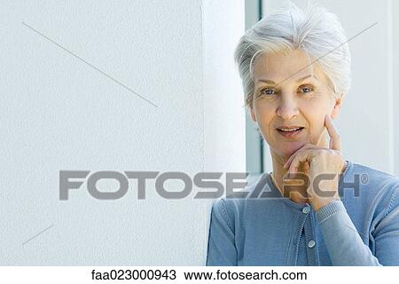 Stock Image - Senior woman smiling at camera, portrait. Fotosearch