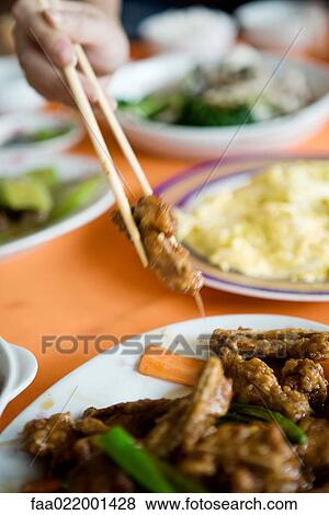 Several prepared dishes on table, person reaching for meat with chopsticks, cropped view View Large Photo Image Stock Photo - Several prepared dishes on table, person reaching for meat with chopsticks, cropped view. Fotosearch