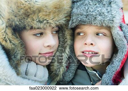 Sister and brother wearing fur caps, smiling at each other, portrait View Large Photo Image Stock Image - Sister and brother wearing fur caps, smiling at each other, portrait. Fotosearch