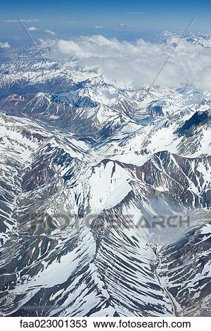 Stock Image - Snow-covered mountain range, aerial view. Fotosearch