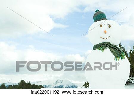Stock Image - Snowman dressed in hat and scarf, portrait. Fotosearch