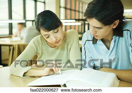 Stock Photo - Students studying together in university library. Fotosearch
