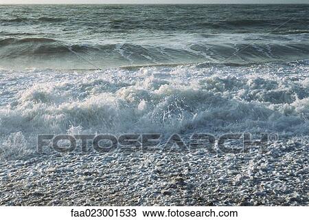 Stock Image - Surf washing over shore. Fotosearch