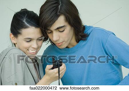 Teen couple looking at cell phone together View Large Photo Image Stock Image - Teen couple looking at cell phone together. Fotosearch