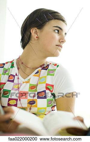 Teen girl holding book, looking away, portrait View Large Photo Image Stock Image - Teen girl holding book, looking away, portrait. Fotosearch
