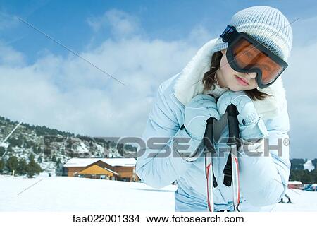 Picture - Teen girl leaning on ski sticks, in snowy landscape, portrait. Fotosearch