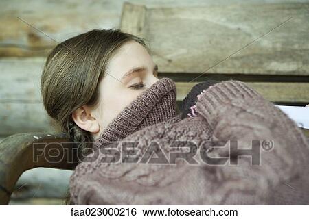 Teen girl lying down with turtleneck pulled up over face and mouth, eyes closed View Large Photo Image Stock Photograph - Teen girl lying down with turtleneck pulled up over face and mouth, eyes closed. Fotosearch