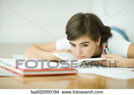 Teen girl lying on floor, doing homework View Large Photo Image Picture - Teen girl lying on floor, doing homework. Fotosearch