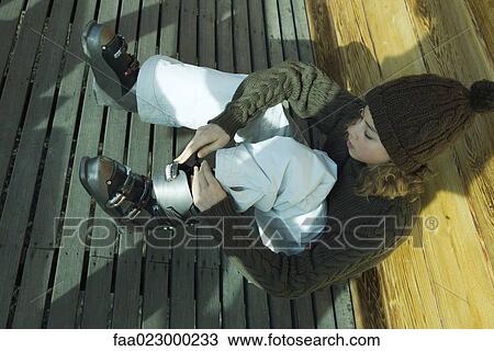 Teen girl putting on ski boots View Large Photo Image Stock Image - Teen girl putting on ski boots. Fotosearch