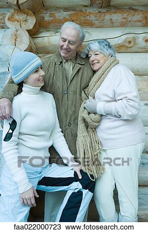 Teen girl with grandparents, wearing winter clothes, standing in front of log cabin, portrait View Large Photo Image Stock Image - Teen girl with grandparents, wearing winter clothes, standing in front of log cabin, portrait. Fotosearch