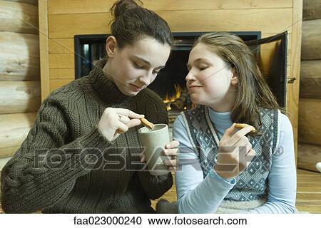 Teen girls having snack by fire place View Large Photo Image Stock Image - Teen girls having snack by fire place. Fotosearch
