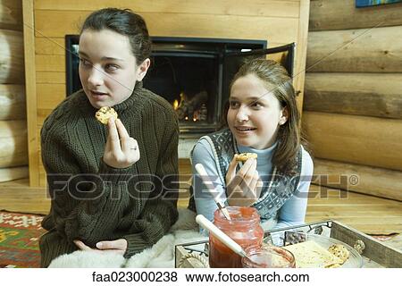 Teen girls having snack by fire place View Large Photo Image Stock Photo - Teen girls having snack by fire place. Fotosearch
