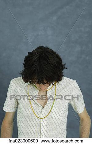 Stock Image - Teenage boy with head down, portrait. Fotosearch