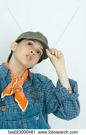 Teenage girl adjusting cap, looking up, portrait View Large Photo Image Stock Image - Teenage girl adjusting cap, looking up, portrait. Fotosearch