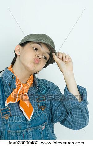 Teenage girl adjusting cap, puckering lips, looking away, portrait View Large Photo Image Stock Image - Teenage girl adjusting cap, puckering lips, looking away, portrait. Fotosearch