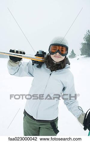 Teenage girl carrying skis on shoulder, smiling at camera View Large Photo Image Stock Image - Teenage girl carrying skis on shoulder, smiling at camera. Fotosearch