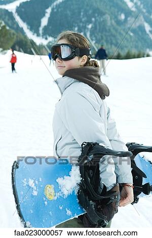 Teenage girl carrying snowboard behind back, waist up View Large Photo Image Stock Photo - Teenage girl carrying snowboard behind back, waist up. Fotosearch
