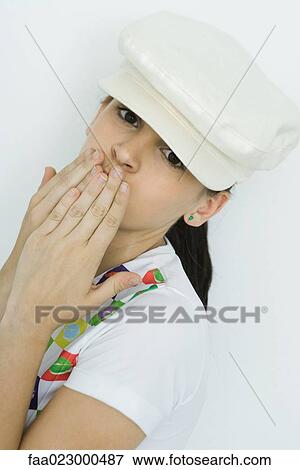 Teenage girl covering mouth with hands, looking at camera, portrait View Large Photo Image Stock Photo - Teenage girl covering mouth with hands, looking at camera, portrait. Fotosearch