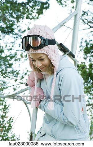 Teenage girl holding on to ski lift, looking over side View Large Photo Image Stock Photograph - Teenage girl holding on to ski lift, looking over side. Fotosearch