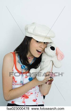 Teenage girl holding stuffed toy, smiling at camera, portrait View Large Photo Image Stock Photo - Teenage girl holding stuffed toy, smiling at camera, portrait. Fotosearch