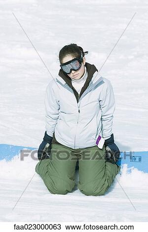 Teenage girl kneeling in snow with snowboard, looking at camera View Large Photo Image Stock Image - Teenage girl kneeling in snow with snowboard, looking at camera. Fotosearch