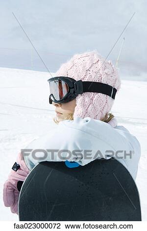 Teenage girl leaning against snowboard, looking away View Large Photo Image Stock Image - Teenage girl leaning against snowboard, looking away. Fotosearch