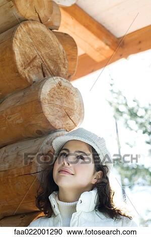 Teenage girl looking up, standing next to log cabin, portrait View Large Photo Image Stock Image - Teenage girl looking up, standing next to log cabin, portrait. Fotosearch