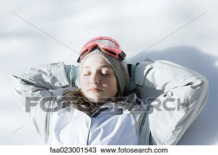 Teenage girl lying on snow with hands behind head and eyes closed View Large Photo Image Stock Image - Teenage girl lying on snow with hands behind head and eyes closed. Fotosearch