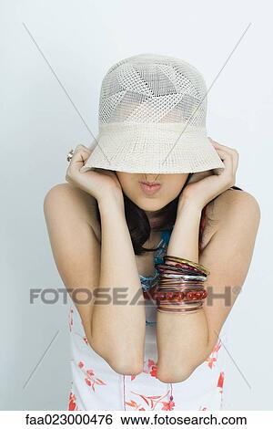 Teenage girl pulling hat down over face, making faces, portrait View Large Photo Image Stock Photograph - Teenage girl pulling hat down over face, making faces, portrait. Fotosearch