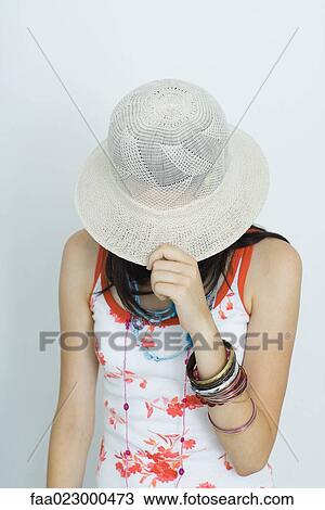 Teenage girl pulling hat over face, portrait View Large Photo Image Stock Image - Teenage girl pulling hat over face, portrait. Fotosearch