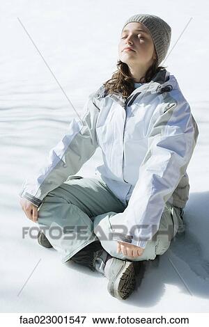 Teenage girl sitting indian style on snow with eyes closed and head back, full length View Large Photo Image Stock Photo - Teenage girl sitting indian style on snow with eyes closed and head back, full length. Fotosearch