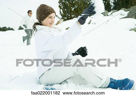 Teenage girl sitting on ground in snow, throwing snowball, side view View Large Photo Image Stock Image - Teenage girl sitting on ground in snow, throwing snowball, side view. Fotosearch