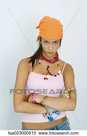 Stock Photography - Teenage girl staring at camera, arms folded, head down, portrait. Fotosearch
