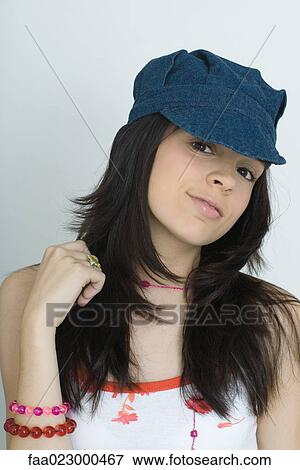 Teenage girl wearing cap, smiling at camera, portrait View Large Photo Image Stock Photo - Teenage girl wearing cap, smiling at camera, portrait. Fotosearch