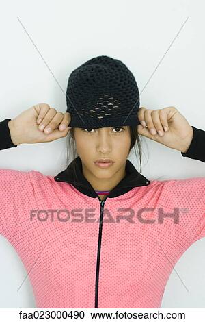 Teenage girl wearing knit hat, looking at camera, portrait View Large Photo Image Stock Image - Teenage girl wearing knit hat, looking at camera, portrait. Fotosearch