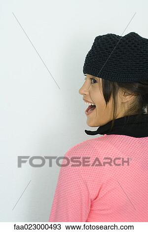 Teenage girl wearing knit hat, smiling, looking away, portrait View Large Photo Image Stock Image - Teenage girl wearing knit hat, smiling, looking away, portrait. Fotosearch