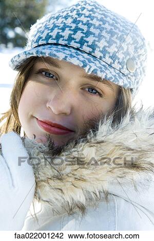 Stock Image - Teenage girl wearing parka and cap, close-up portrait. Fotosearch