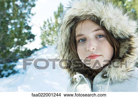 Picture - Teenage girl wearing parka in snowy landscape, portrait. Fotosearch