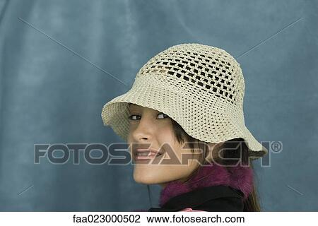 Teenage girl wearing sun hat, smiling over shoulder at camera, portrait View Large Photo Image Stock Image - Teenage girl wearing sun hat, smiling over shoulder at camera, portrait. Fotosearch