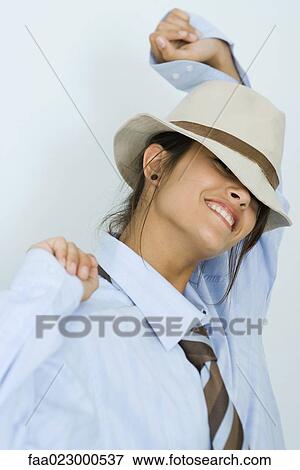 Teenage girl wearing tie and hat, smiling at camera, arms raised, portrait View Large Photo Image Stock Photo - Teenage girl wearing tie and hat, smiling at camera, arms raised, portrait. Fotosearch